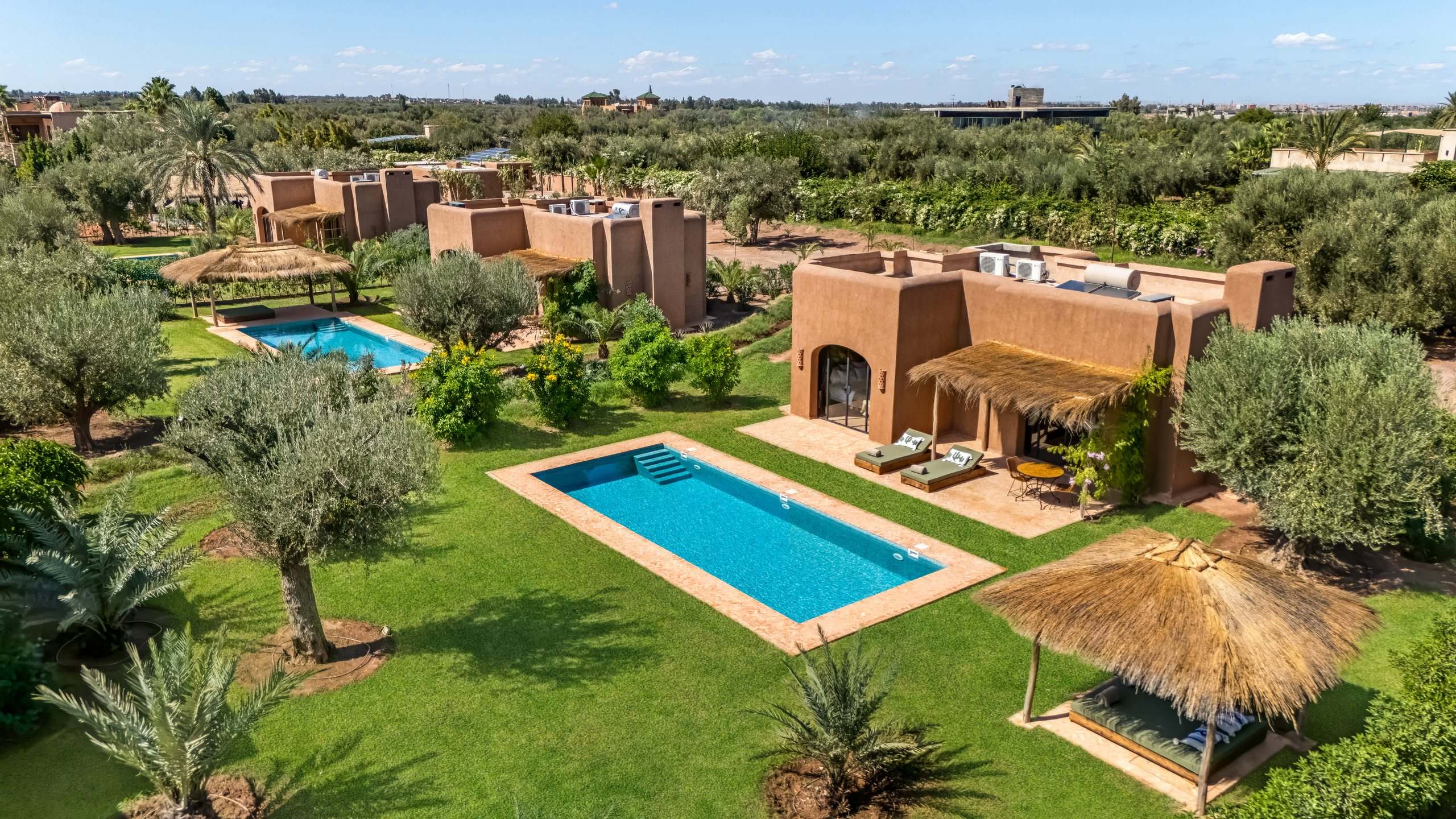Lodges et piscines entre les oliviers, vus du ciel