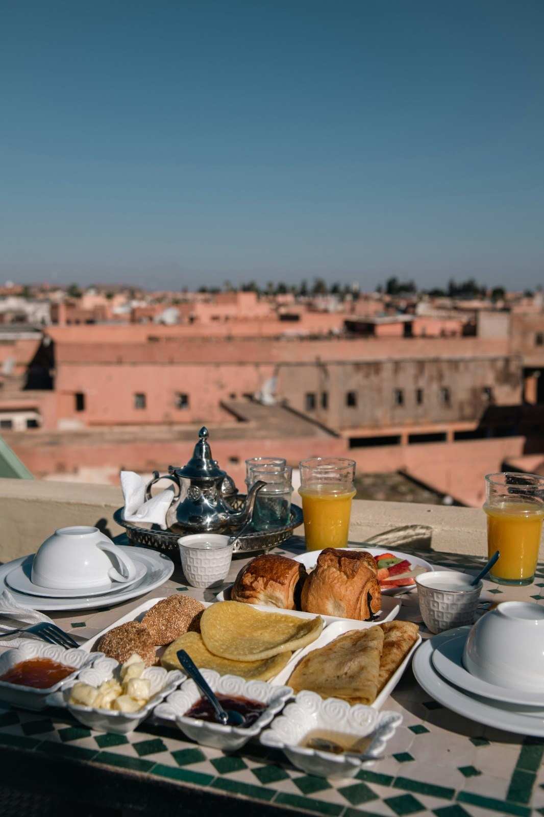 Petit-déjeuner marocain sur une terrasse face à la médina