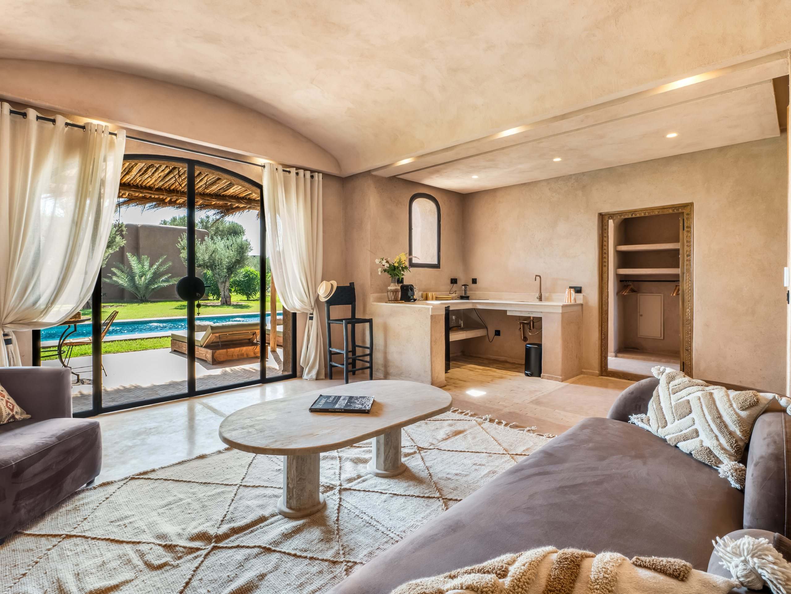Salon ouvert sur la piscine et kitchenette